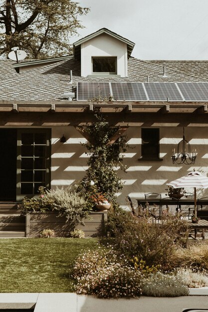 A charming rural guesthouse in the Spanish countryside, featuring solar panels on the roof and a vegetable garden in the front.