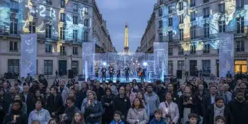 Commémoration France 2026 : Évolution de la Mémoire Collective Groupe divers participant à une commémoration moderne en France avec projections numériques et écrans interactifs.