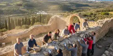 Voluntariado Cultural España 2026: Guía Completa y Paso a Paso Voluntarios restaurando un muro histórico en España bajo el sol, símbolo de conservación cultural.