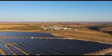 Solar farm and wind turbines symbolizing renewable energy in Spain.