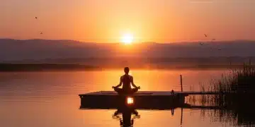 Person meditating by a lake at sunrise, symbolizing morning peace and productivity